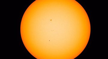 Mercúrio (o ponto preto pequenino no centro da foto) passou entre o Sol e a Terra na última segunda-feira (9/5) - Foto: NASA