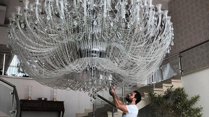 Luciano Camargo ficou pequeno perto do lustre gigantesco que ilumina a sala principal de sua mansão - Foto: Reprodução/ Instagram